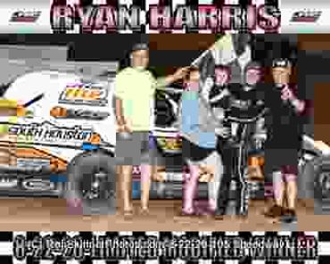 Four people posing in front of a race car.