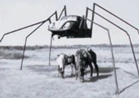 A large spider-like sculpture with a car body and long metal legs.