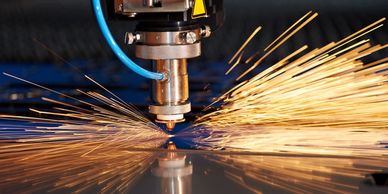 Industrial machine cutting metal with bright sparks flying.