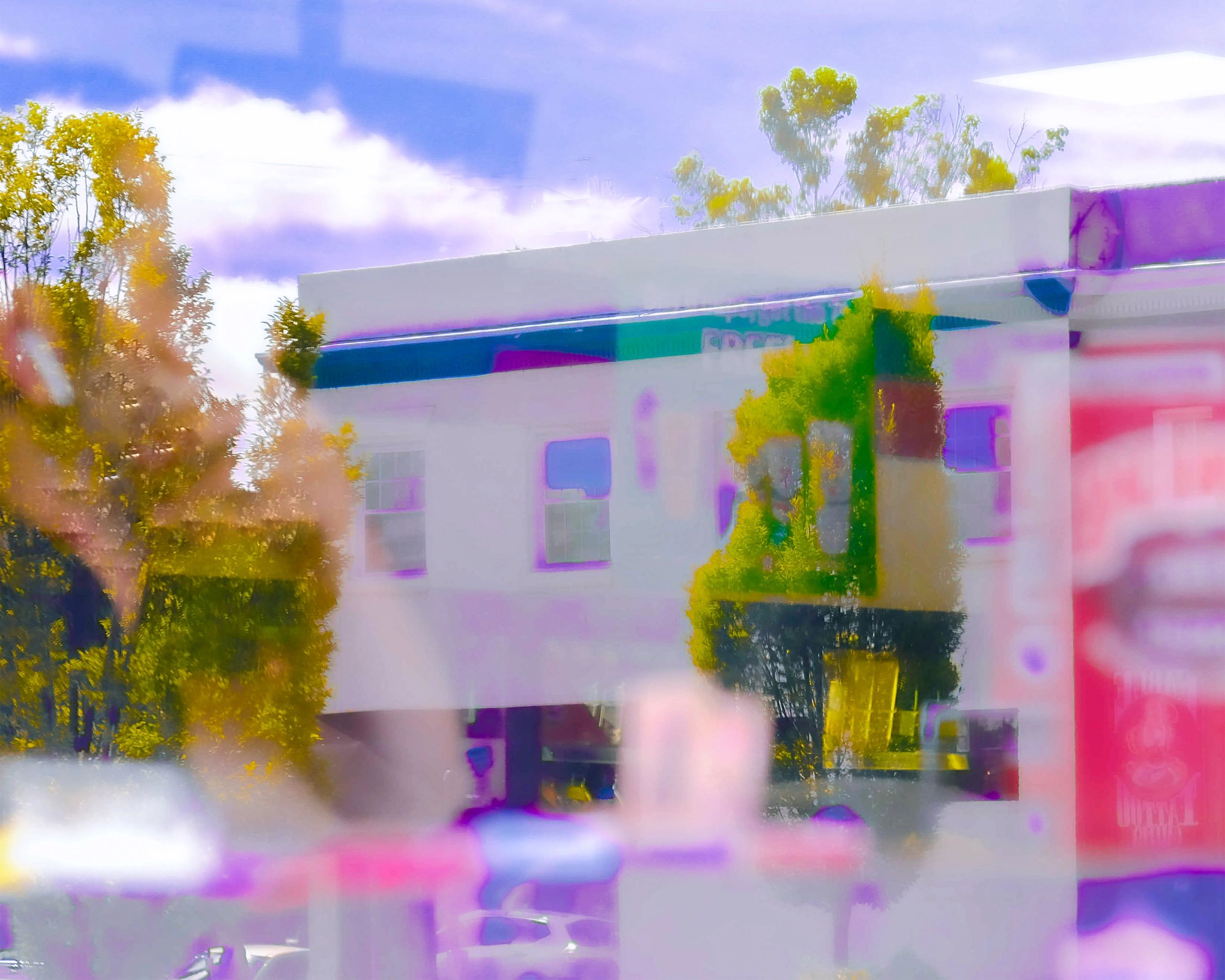 Blurred colorful reflection of trees and a building.