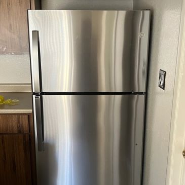 Stainless steel top freezer refrigerator in a kitchen.