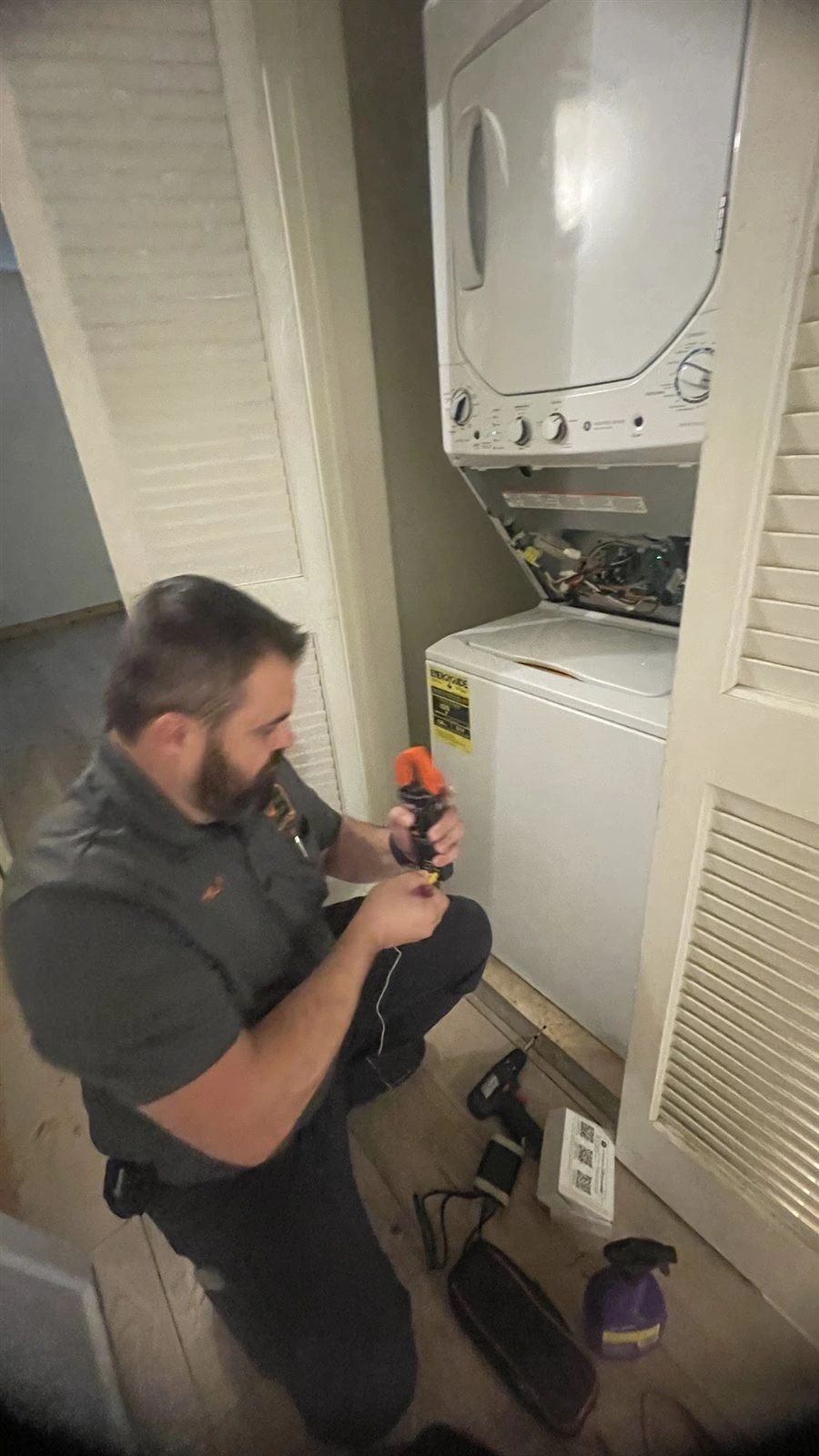MSJ Appliance Repair technician servicing a stacked washer and dryer