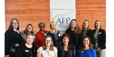 A group of women standing in front of a banner.