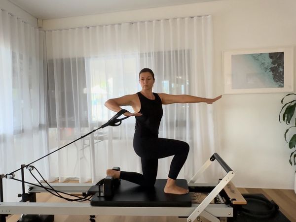 Kaia Pilates performing upper body reformer exercise