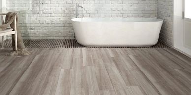 Modern bathroom with freestanding tub and wooden floor.