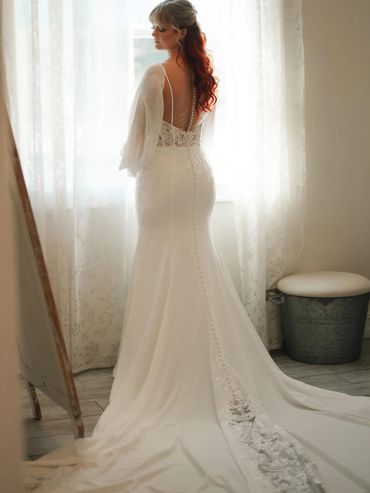 Bride in elegant white wedding dress with a long train.