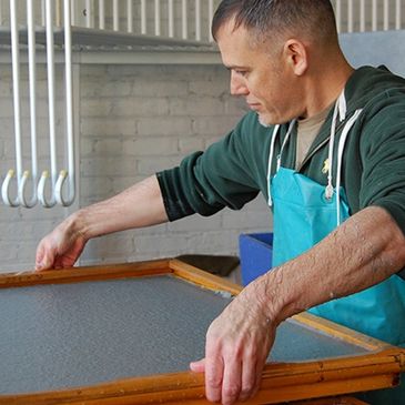 Man working with a wooden frame in a workshop.
