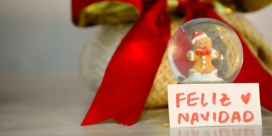 Christmas snow globe with a gingerbread figure and Feliz Navidad sign.