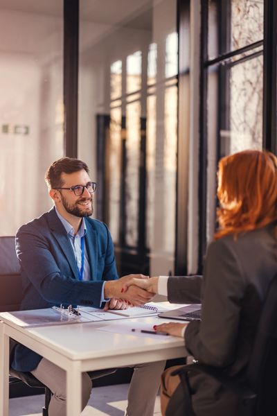 Happy bank manager shaking hands with a client after successful agreement in the office