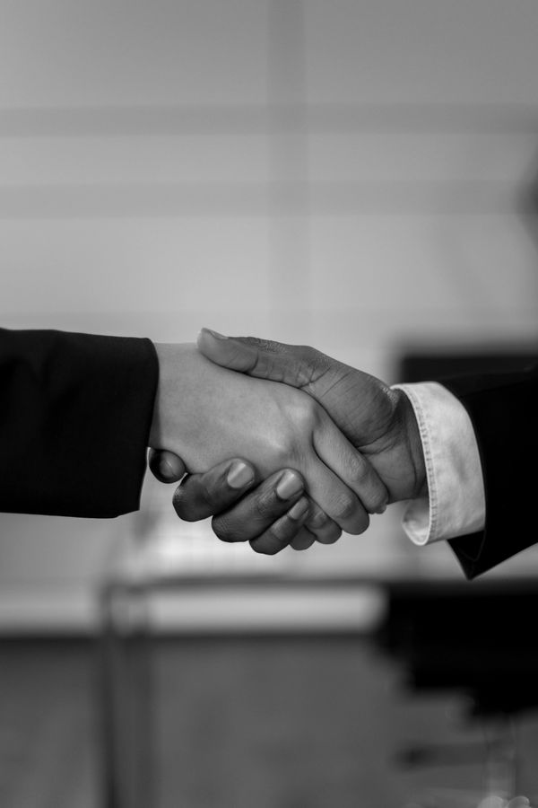 Two people shaking hands in a professional setting.