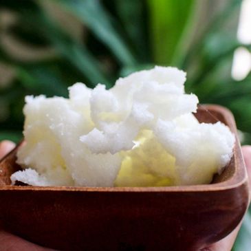 Organic shea butter displayed in a wooden bowl. 