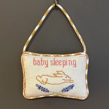 Needlepoint baby sleeping door hanger - finishing done in hanging pillow style. Stuffed and welted