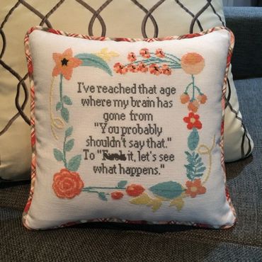 Plaid fabric was used to create custom welting for this counted cross stitch pillow.