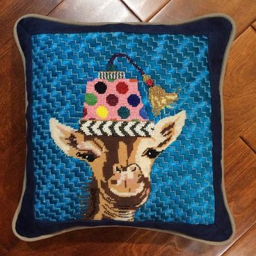 Needlepoint pillow finisher used ultra suede to frame the needlepoint and a second fabric as piping