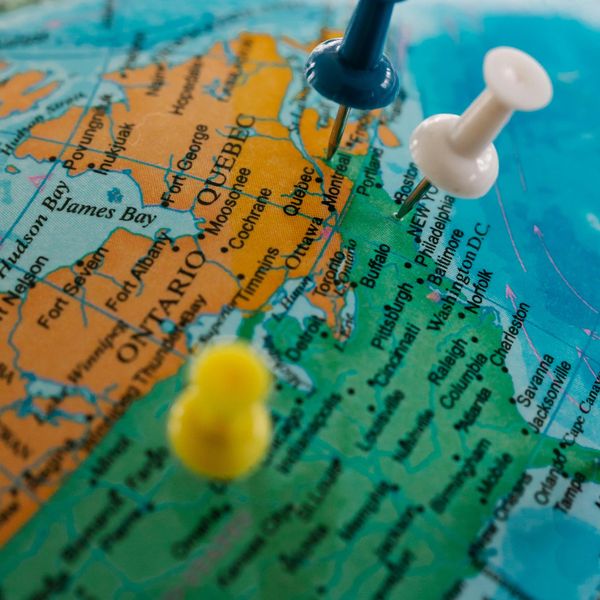 A vibrant sunset over a tranquil beach with silhouettes of palm trees in the foreground.