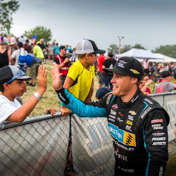 Ryan Beat high five's a young fan at the race track.
