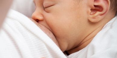 A newborn baby breastfeeding peacefully.