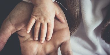 A child's hand resting on an adult's hand.