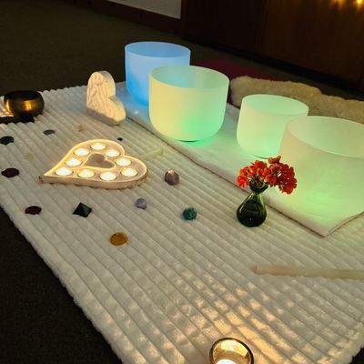 Meditative setup with glowing bowls, candles, and crystals.
