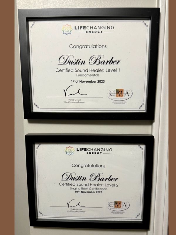 Two framed certificates for Dustin Barber as a Certified Sound Healer from Life Changing Energy.