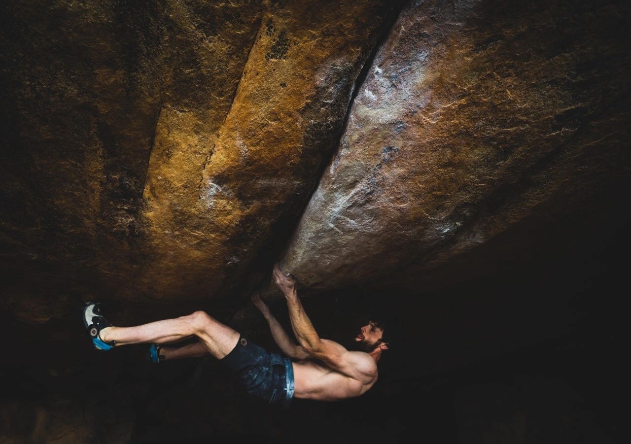 Man bouldering on an overhanging rock wall.