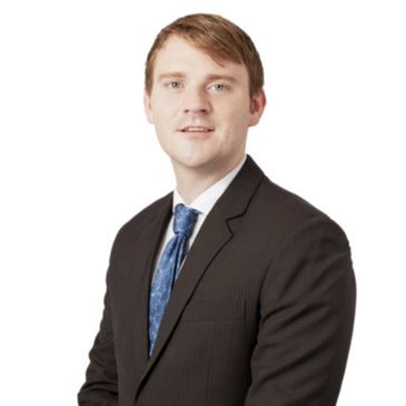 Professional young man in a suit and tie posing for a portrait.