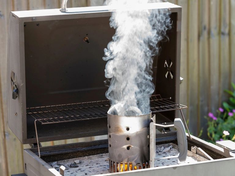 Photo of chimney starter on a grill Photo of chimney starter on a grill