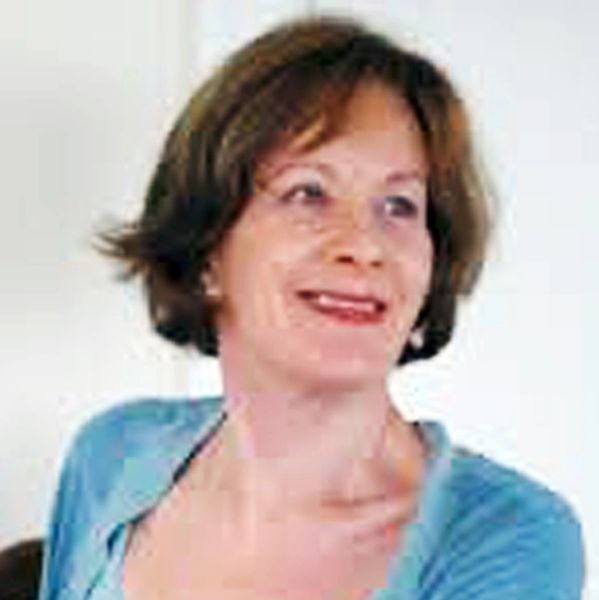 A woman with short brown hair smiling and wearing a blue top.