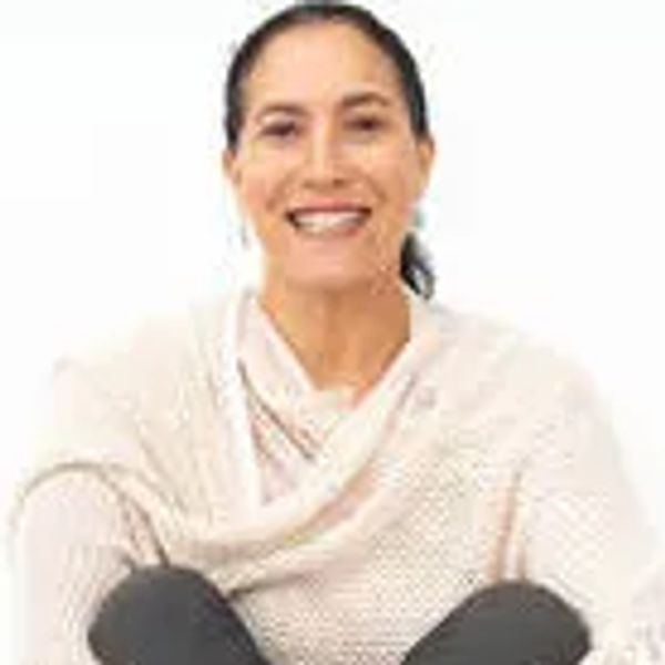 Smiling woman in a light sweater sitting comfortably.