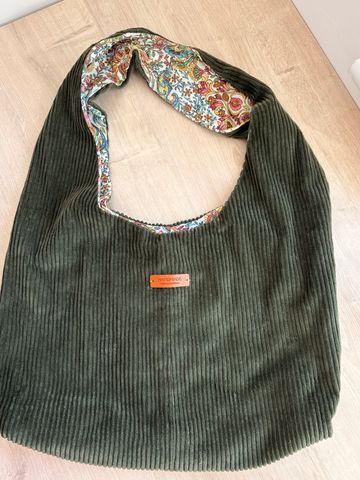 Soft green corduroy velvet bag with floral inner lining and leather 'HANDMADE' tag.