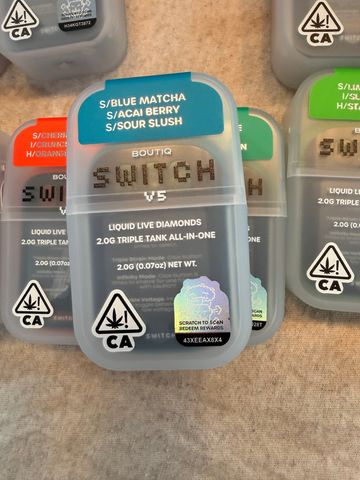 Various colorful cannabis product containers labeled with strains and safety symbols.