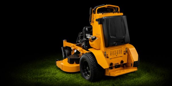 Yellow riding lawn mower on grass.