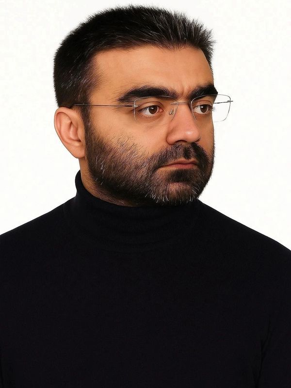 Man with glasses and beard in black turtleneck.