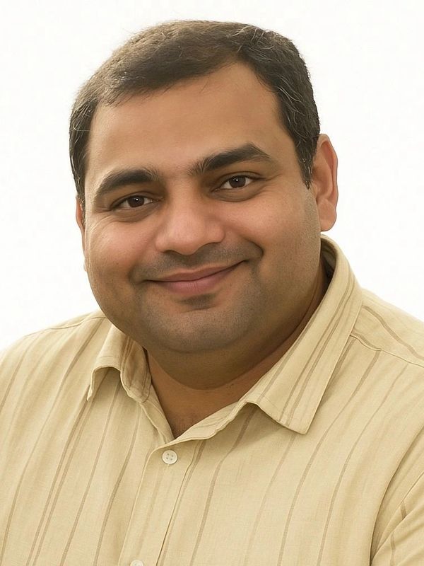 Smiling man in beige striped shirt.