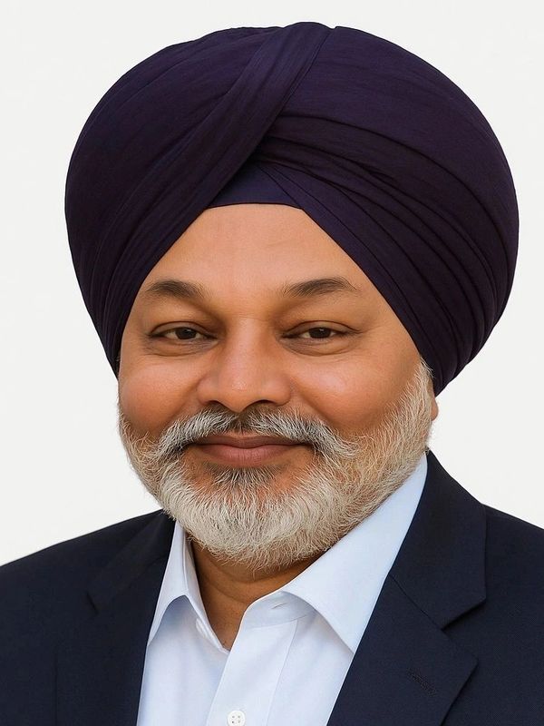 Smiling man wearing a dark turban and suit.