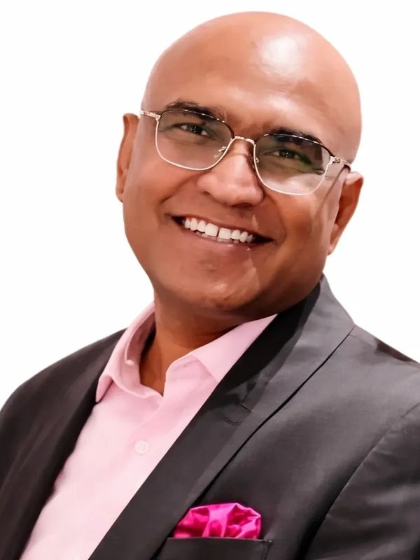 Smiling bald man in glasses and formal suit.