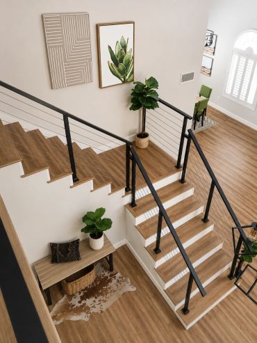 Modern staircase with wooden steps and black railings in a bright home.