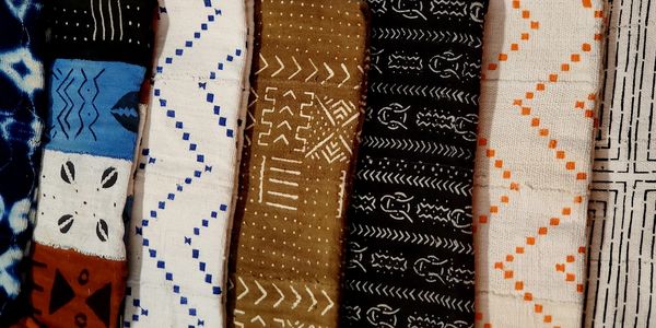 This image showcases a beautiful collection of African mud cloth fabrics.