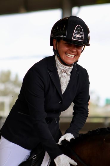 A joyful equestrian rider smiling while riding.