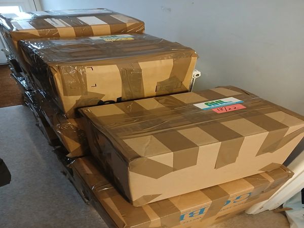 Stacked cardboard boxes sealed with tape indoors.