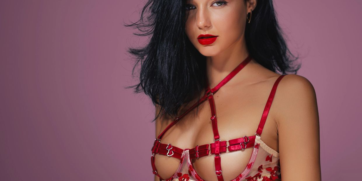 A striking fashion image featuring a model wearing a bold red bra in a modern, elegant setting.