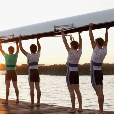 Rowers holding a boat with one in a different color uniform