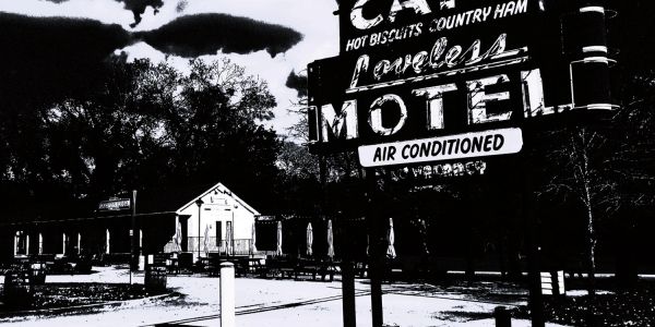 Old motel sign for Loveless Motel in black and white.