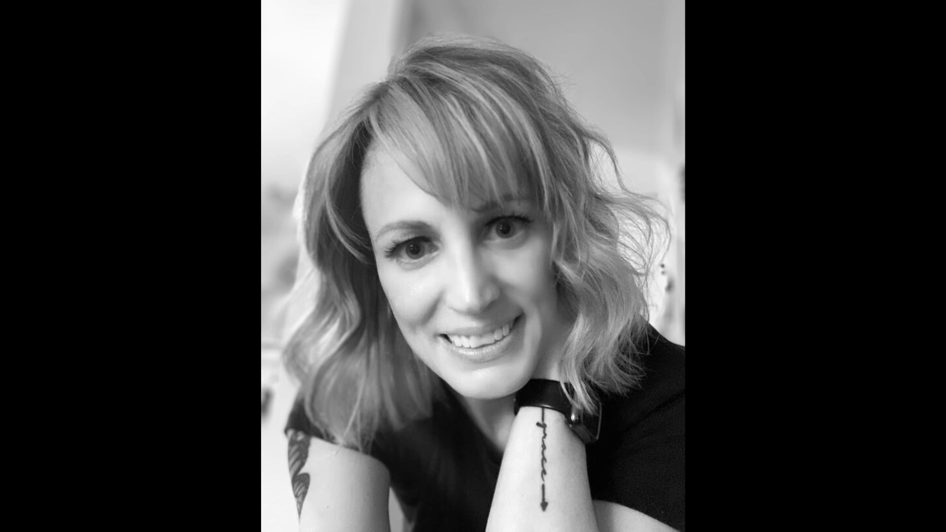 lori: woman with chin-length wavy highlighted hair, hand under her chin, smiling at the camera