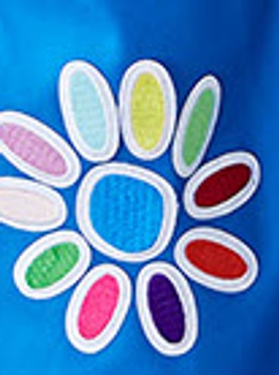 Colorful flower-shaped patches on a blue fabric background.