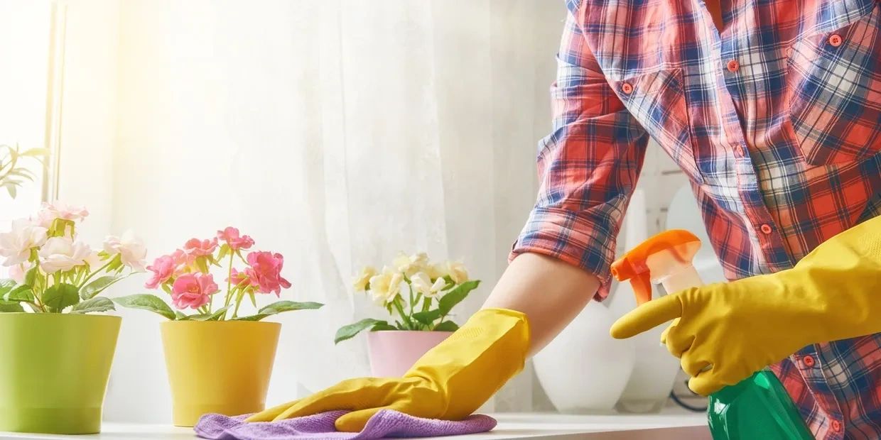 A person cleaning wearing yellow gloves.