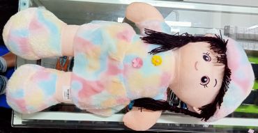 Colorful stuffed doll with black hair and a hat.