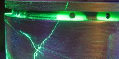 Close-up of a cracked container illuminated by green light.