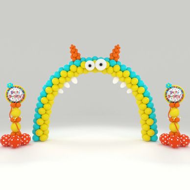 Colorful balloon arch with monster face and birthday signs.