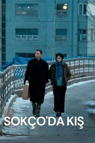 A man and woman walk together on a cold, snowy street in Sokcho.